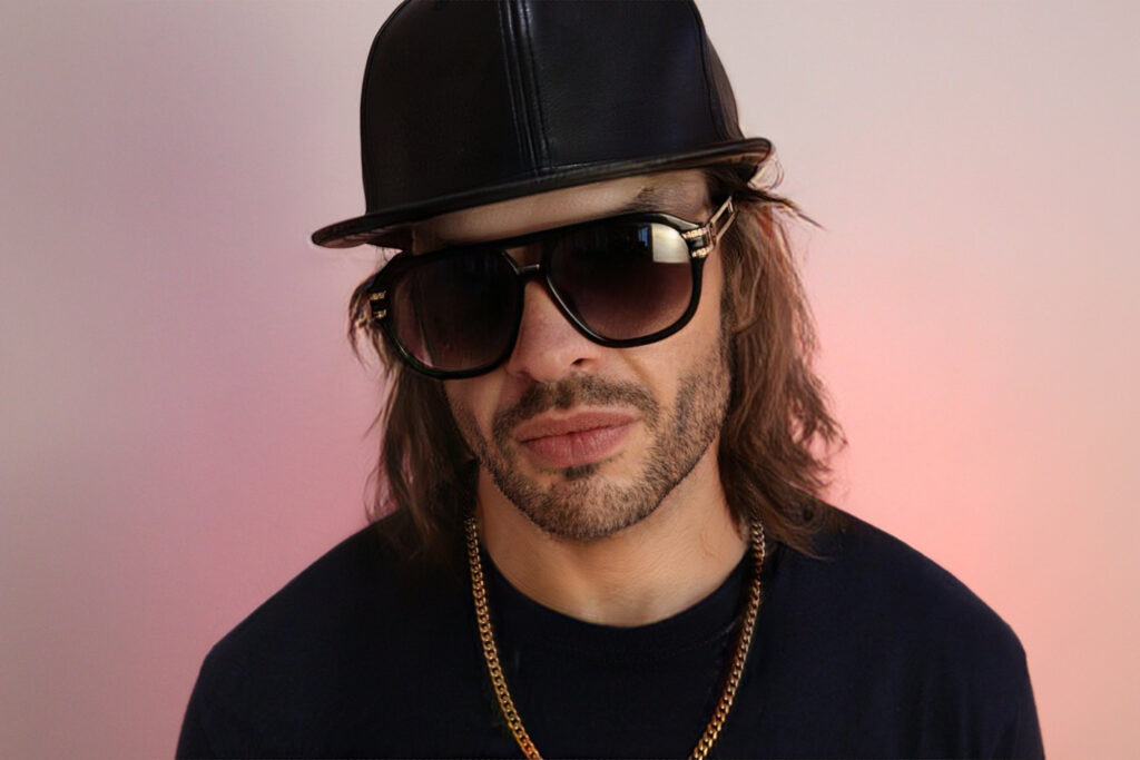 male dj with black sunglasses and hat and gold chain